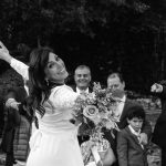 Mujer vestida con su vestido de boda con el ramo en la mano